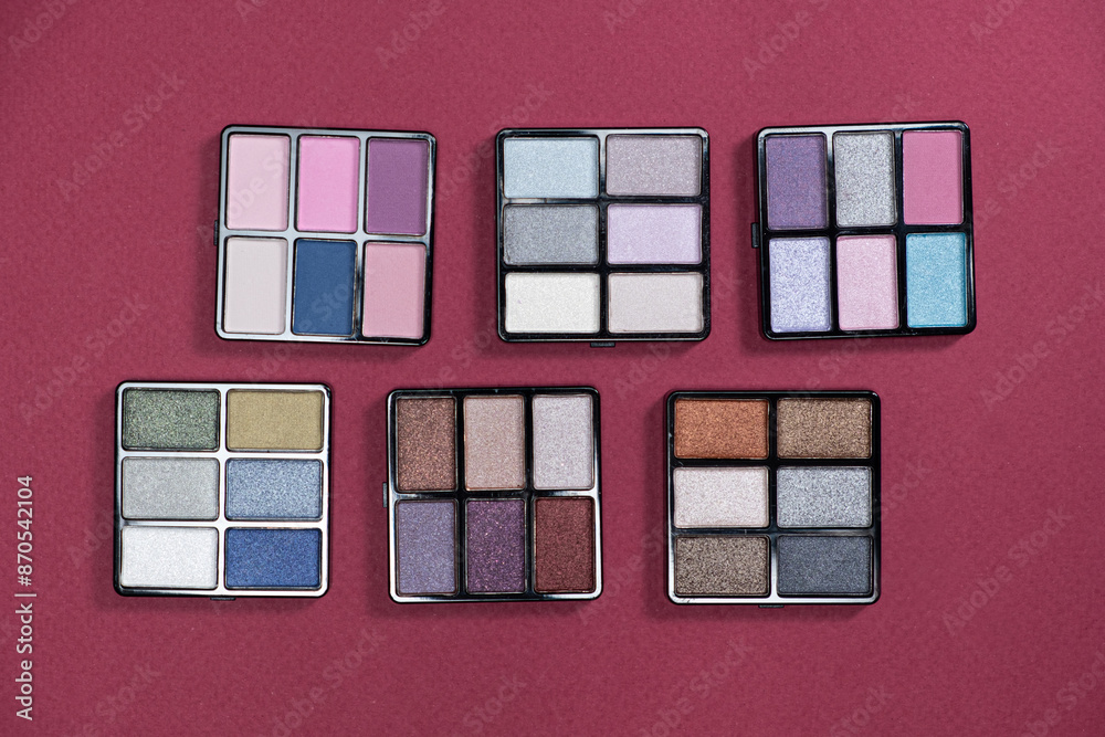 Fototapeta premium A set of multi-colored eyeshadow on a pink background. Eye makeup