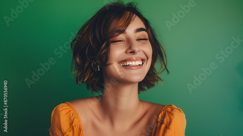 A joyful millennial woman with a confident smile, posing against a solid green background