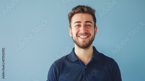 A millennial man in a polo shirt, smiling confidently at the camera against a solid light blue background