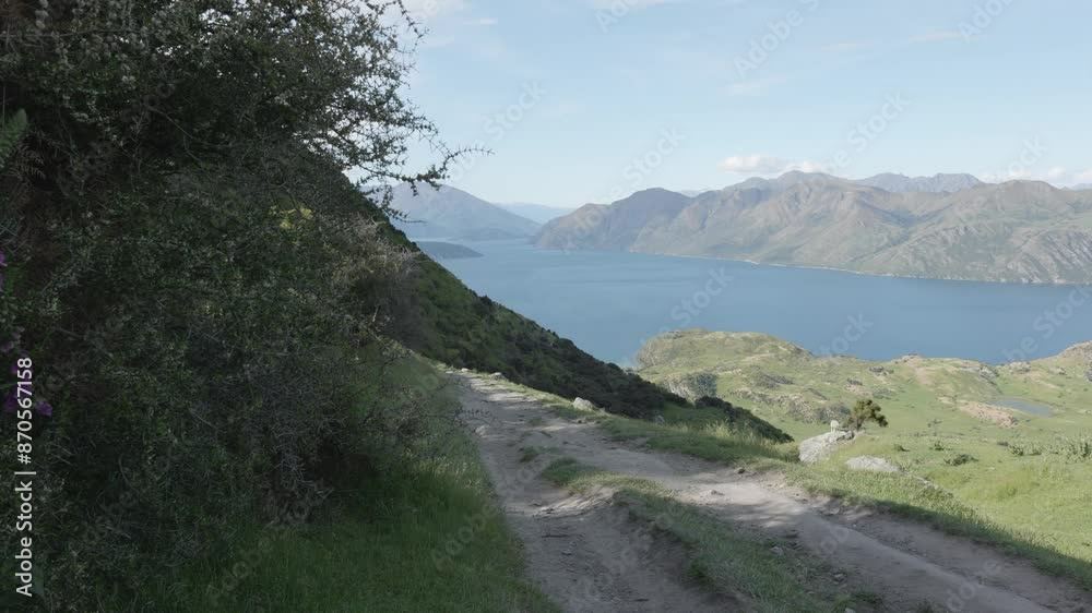 Gravel path to Roy's Peak, mountains and Lake Wanaka on a sunny summer day in Wanaka, New Zealand Gravel path to Roy's Peak, mountains and Lake Wanaka on a sunny summer day in Wanaka, New Zealand