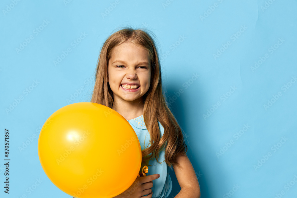Little girl holding a yellow balloon on a bright blue background with plenty of copy space for text Little girl holding a yellow balloon on a bright blue background with plenty of copy space for text