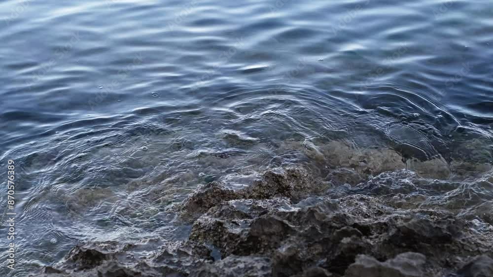 Calm ripples or waves crashing on sharp rocks. Continuously changing transparent sea or ocean surface with reflections and little bubbles. Abstract meditative slow motion of crystal clear water. Calm ripples or waves crashing on sharp rocks. Continuously changing transparent sea or ocean surface with reflections and little bubbles. Abstract meditative slow motion of crystal clear water.
