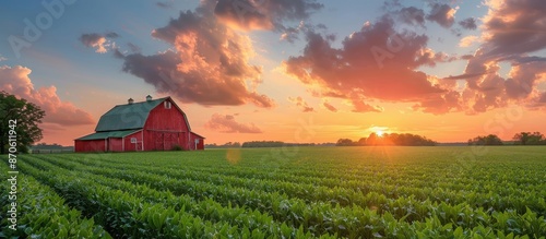 Stunning red barn in a lush green field at sunset with a dramatic sky and clouds, capturing the essence of rural tranquility. photo
