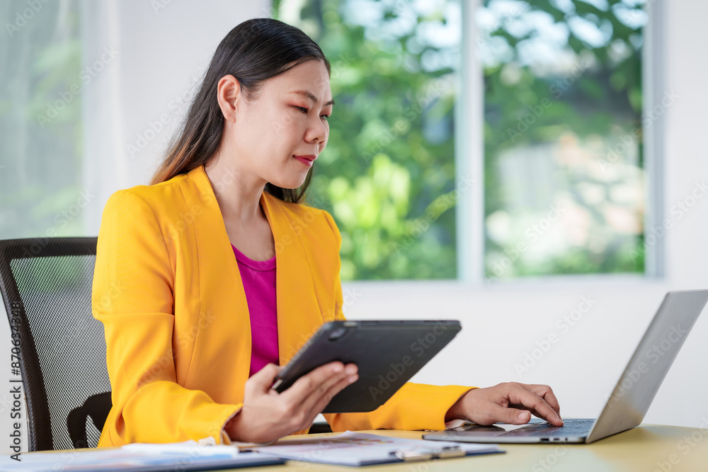 An Asian businesswoman is diligently working at an accountant's desk, surrounded by financial documents and a laptop, meticulously analyzing data to ensure accurate and efficient financial management. An Asian businesswoman is diligently working at an accountant's desk, surrounded by financial documents and a laptop, meticulously analyzing data to ensure accurate and efficient financial management.