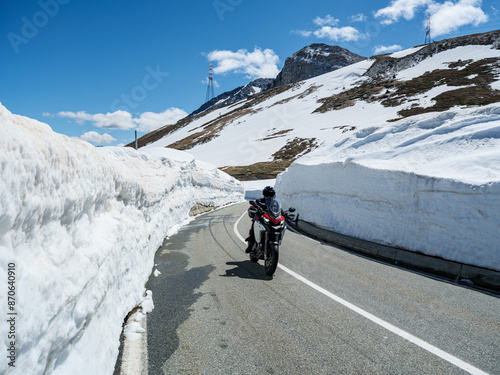 Riding motorcycle in the winter alps, snow banks