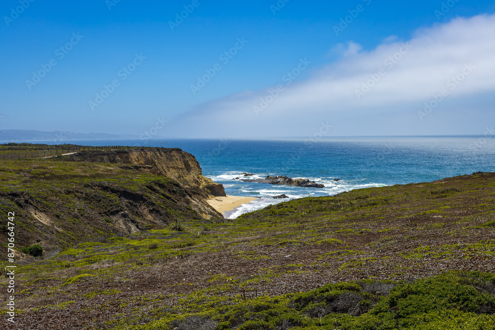 Pacific ocean on sandy Cowell Ranch State beach surrounded by sea cliffs, rocky headlands on summer sunny day in San Mateo County, California Pacific ocean on sandy Cowell Ranch State beach surrounded by sea cliffs, rocky headlands on summer sunny day in San Mateo County, California