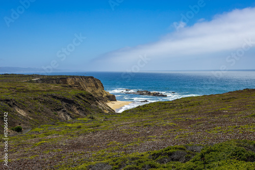 Pacific ocean on sandy Cowell Ranch State beach surrounded by sea cliffs, rocky headlands on summer sunny day in San Mateo County, California photo