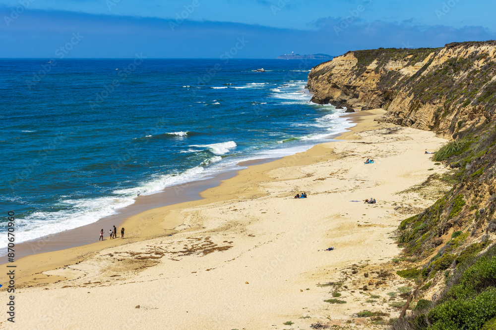 Pacific ocean on sandy Cowell Ranch State beach surrounded by sea cliffs, rocky headlands on summer sunny day in San Mateo County, California Pacific ocean on sandy Cowell Ranch State beach surrounded by sea cliffs, rocky headlands on summer sunny day in San Mateo County, California