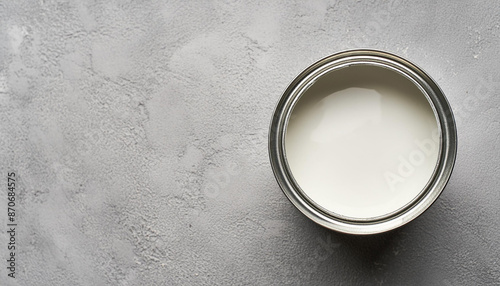 White paint in metal can on cement surface. For wall painting or artwork. Close-up. Top view.