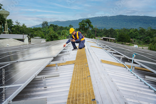 Billede på lærred An engineer with a tablet and utilizing radio communication, meticulously inspects solar panels on a rooftop