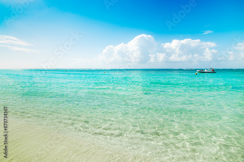 Turquoise water under a blue sky with clouds in a tropical beach