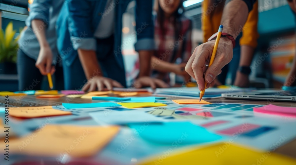 Obraz premium Team collaborating on project with colorful sticky notes and charts in modern workspace symbolizing innovation and cooperation