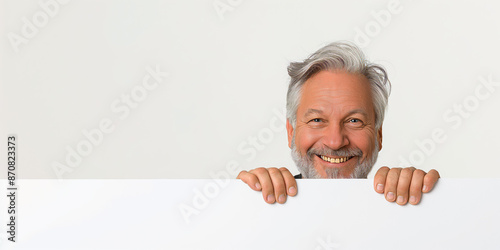 Smiling grey-haired male professor against a neutral backdrop. photo