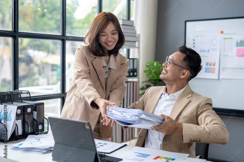 A woman is handing a man a stack of papers A woman is handing a man a stack of papers