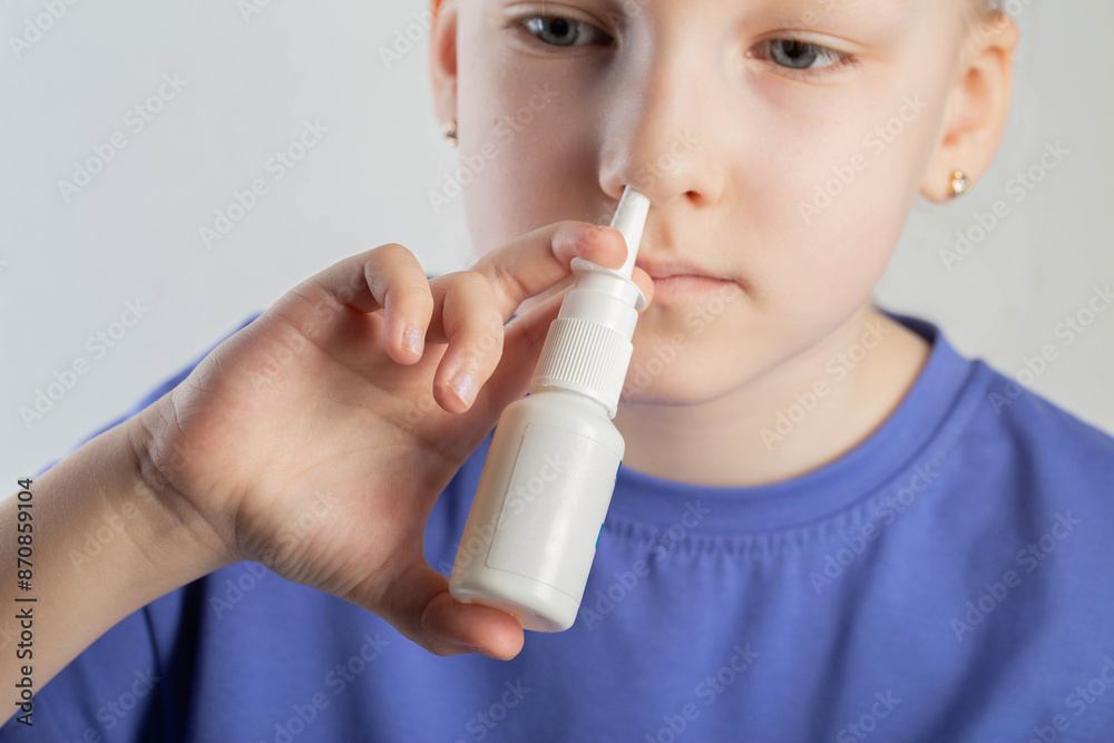 A caucasian girl puts drops into her nose and an anti-inflammatory spray for nasal congestion. Treatment of runny nose and sinusitis. Antibiotic medicinal spray, close-up A caucasian girl puts drops into her nose and an anti-inflammatory spray for nasal congestion. Treatment of runny nose and sinusitis. Antibiotic medicinal spray, close-up