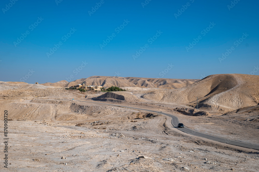 Road Going to An Nabi Musa Mosque and Oasis Garden Seen From Afar Against Clear Blue Sky with a Black Car