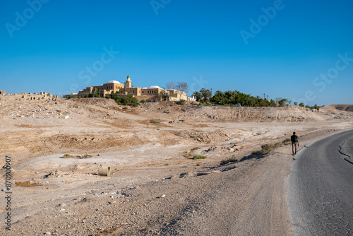 Obraz na płótnie Young Male Explorer Walks Toward An Nabi Musa Mosque and Oasis Garden Seen From Afar w salonie