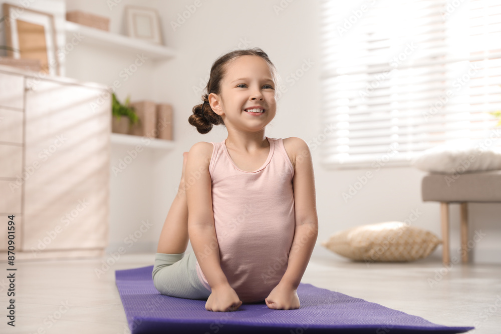 Cute little girl stretching herself on mat at home Cute little girl stretching herself on mat at home