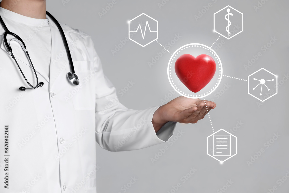 Doctor holding red heart on grey background, closeup. Icons near hand Doctor holding red heart on grey background, closeup. Icons near hand