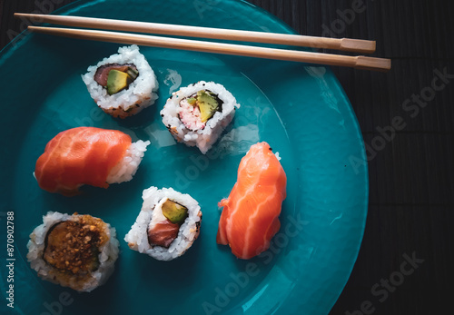 niguiri, hossomaki, variety of japanese food on blue plate with chopsticks photo