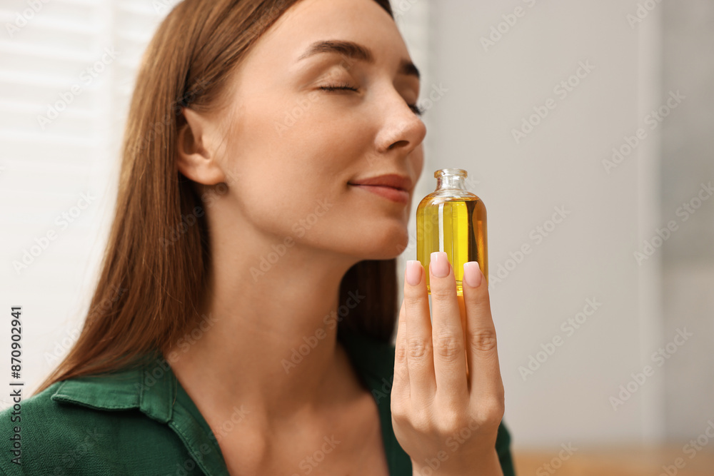 Aromatherapy. Beautiful woman with bottle of essential indoors Aromatherapy. Beautiful woman with bottle of essential indoors