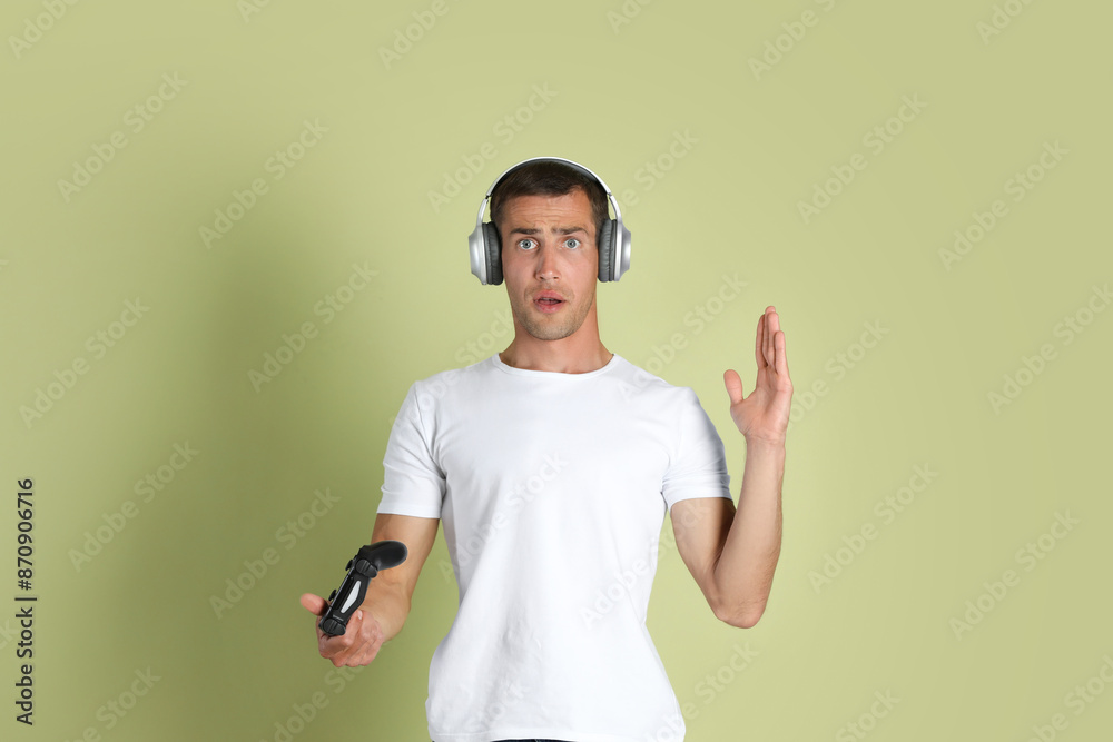 Surprised man controller on light green background Surprised man controller on light green background