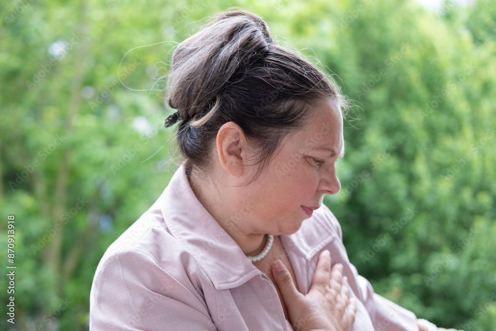 adult woman 55 years old holds chest, experiencing severe heart pain, possibly indicating heart attack, medical emergency, urgency heart health adult woman 55 years old holds chest, experiencing severe heart pain, possibly indicating heart attack, medical emergency, urgency heart health
