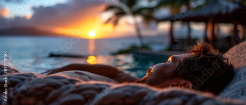  A man reclines in a hammock before a tranquil body of water, framed by a breathtaking sunset photo
