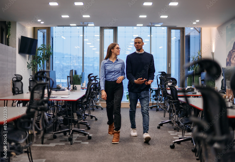 Dynamic Business Collaboration: Blonde Businesswoman and African American Colleague in Modern Office Setting. Dynamic Business Collaboration: Blonde Businesswoman and African American Colleague in Modern Office Setting.