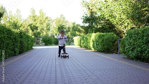 Wallpaper Mural Little boy learning to ride a scooter. Happy kid rides a vehicle smiling adorably approaching camera. Torontodigital.ca