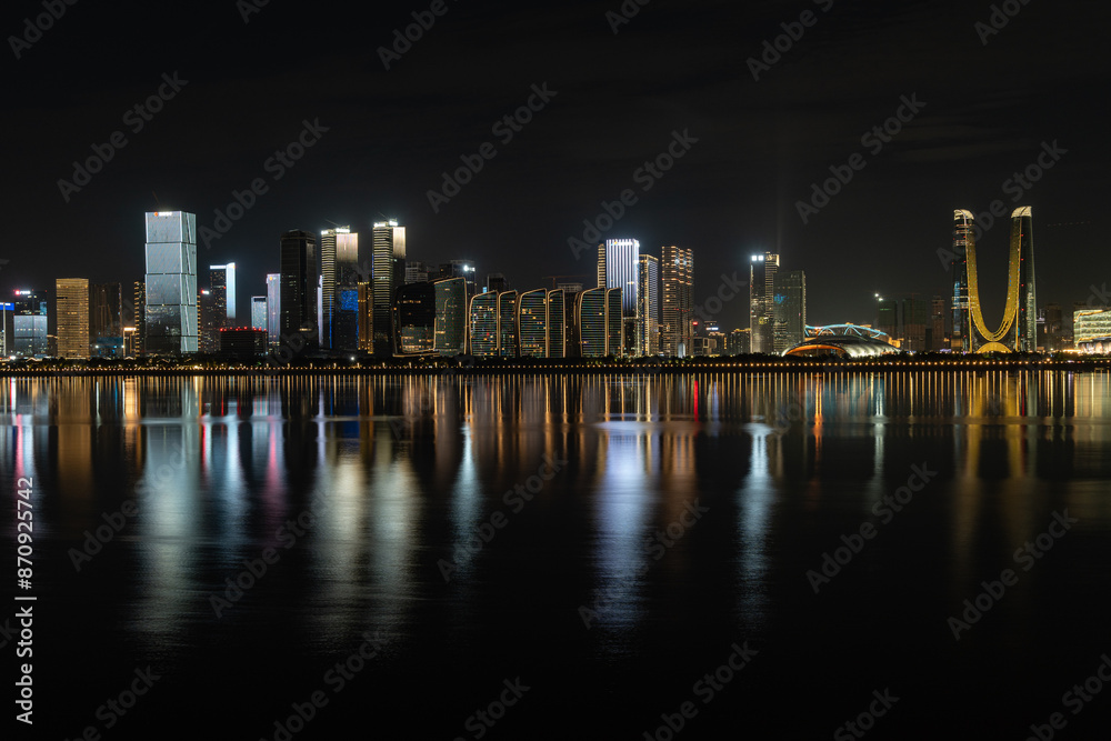 Fototapeta premium Modern city skyline and urban buildings at night in Hangzhou, China, featuring skyscrapers, city lights, nightlife, a vibrant skyline, and a blend of futuristic design landmarks in the Hangzhou CBD
