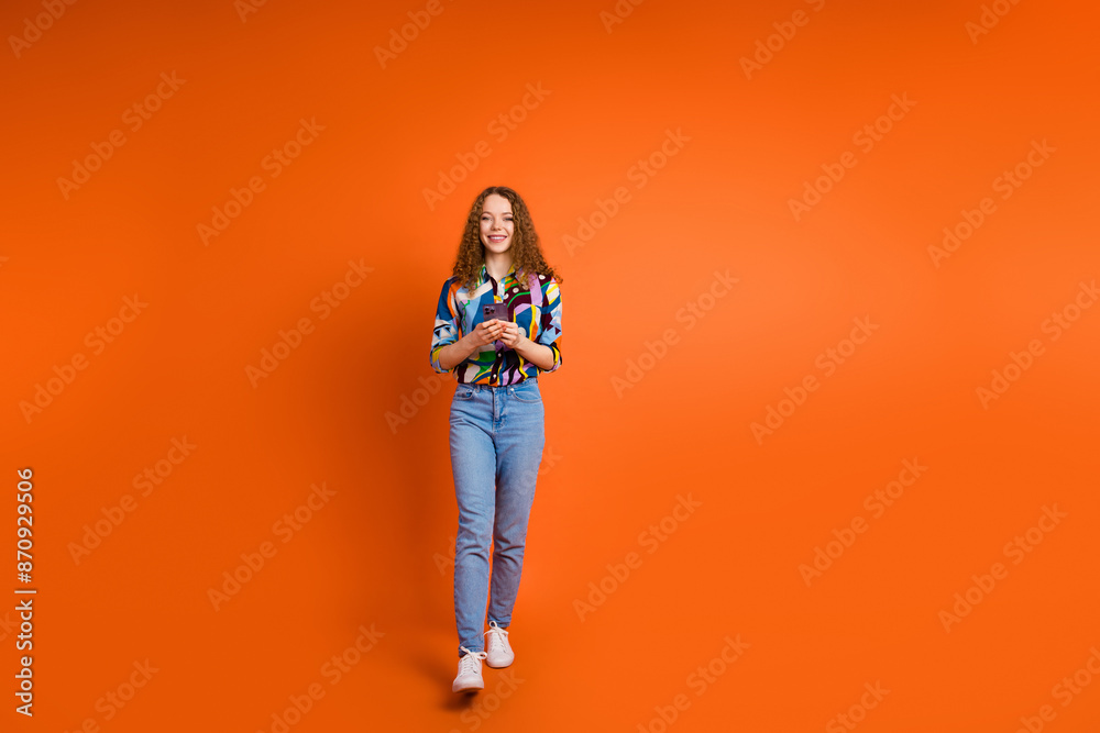 Fototapeta premium Photo of pretty cute girl dressed stylish clothes hold use modern gadget isolated on orange color background