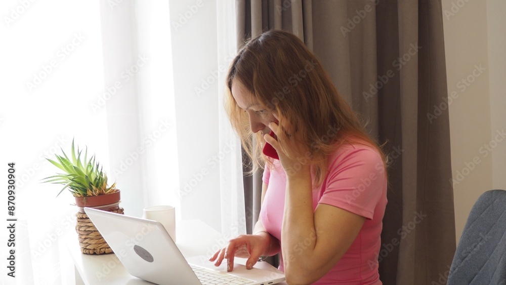 woman working at home on a computer, talking on the phone, businesswoman or student looking at laptop learning, serious girl working or studying computer doing research or preparing for exam online woman working at home on a computer, talking on the phone, businesswoman or student looking at laptop learning, serious girl working or studying computer doing research or preparing for exam online