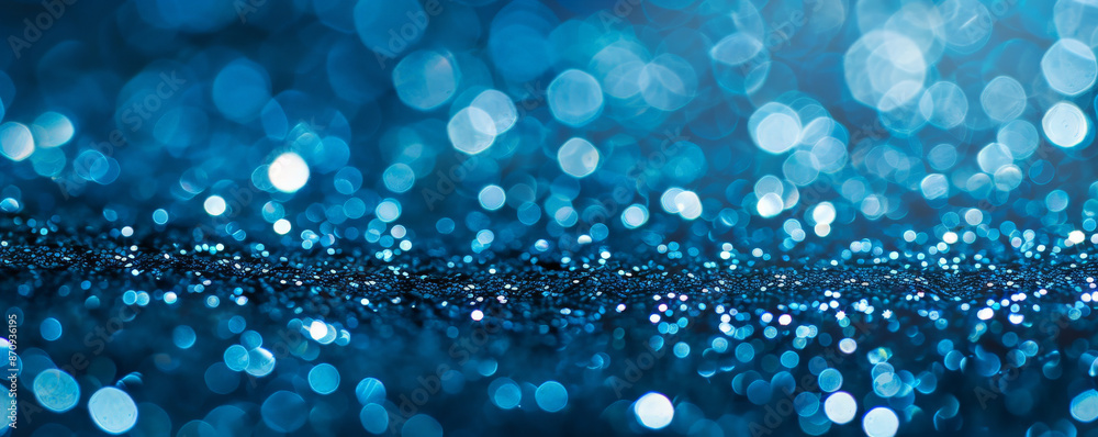 A close-up of blue glitter with selective focus, showcasing the intricate details of the glitter particles while the background fades into a soft, cool blur. A close-up of blue glitter with selective focus, showcasing the intricate details of the glitter particles while the background fades into a soft, cool blur.
