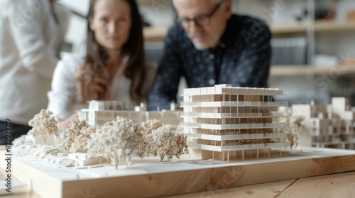Team of architects scrutinizing architectural model with high-tech tools in office