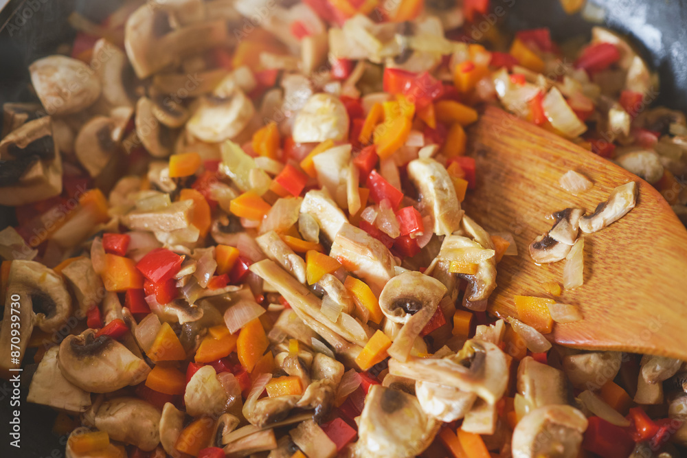 Vegetables are fried in a frying pan, close-up of the process of preparing a vegetarian dish or sauce, steam rising above the vegetables Vegetables are fried in a frying pan, close-up of the process of preparing a vegetarian dish or sauce, steam rising above the vegetables