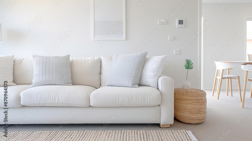 Minimalist living room with white sofa, wooden side table, and beige rug. Minimalist living room with white sofa, wooden side table, and beige rug.