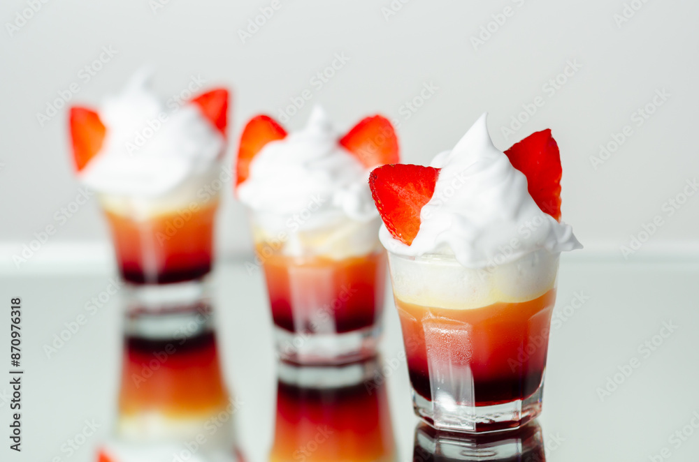 Three glasses of strawberry shot drink with whipped cream Three glasses of strawberry shot drink with whipped cream