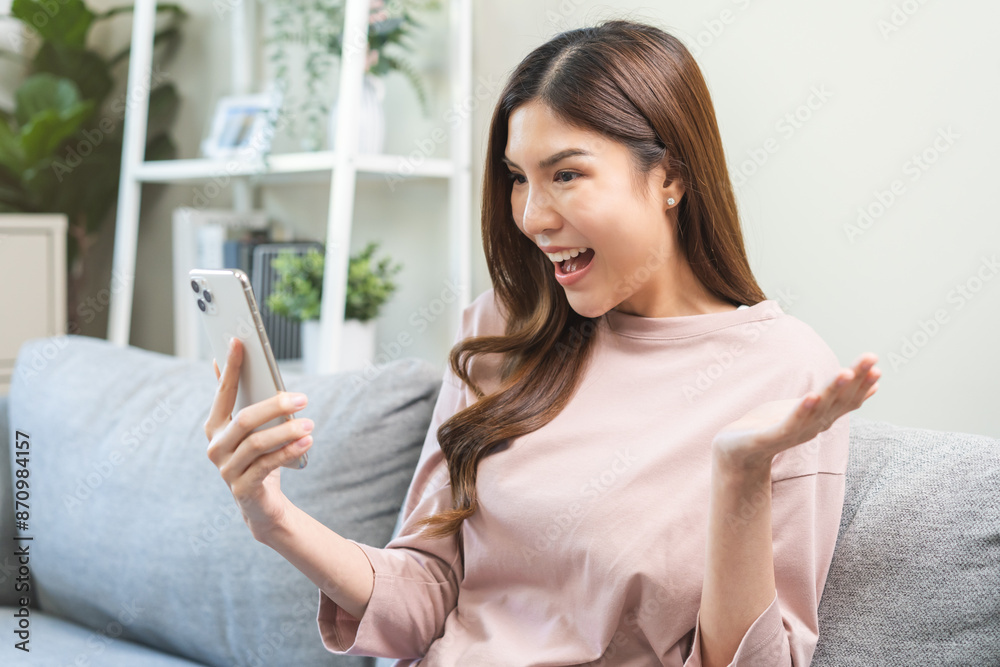 Happy cheerful asian young woman celebrating lottery win or achievement, looking at mobile phone screen app, received good news, enjoy with offer discount for shopping online, making surprise gesture. Happy cheerful asian young woman celebrating lottery win or achievement, looking at mobile phone screen app, received good news, enjoy with offer discount for shopping online, making surprise gesture.