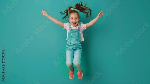 Una bambina salta con gioia. Sfondo azzurro 