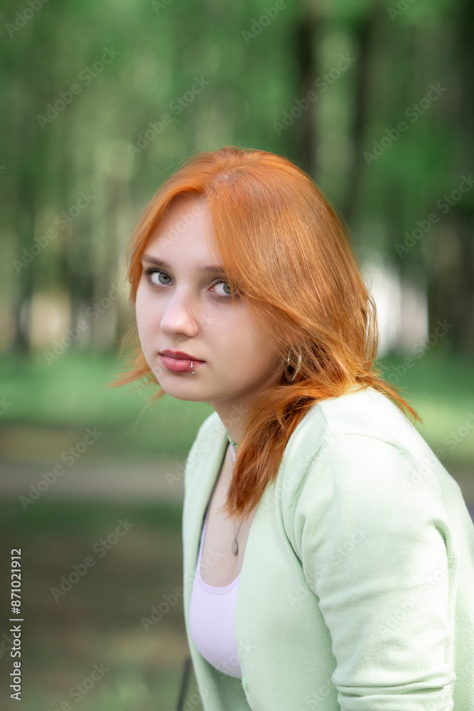Portrait of a young beautiful red-haired girl in an urban environment. Portrait of a young beautiful red-haired girl in an urban environment.