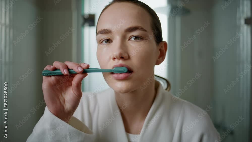 Young woman brushing teeth at home closeup. Pretty girl looking camera cleaning Young woman brushing teeth at home closeup. Pretty girl looking camera cleaning
