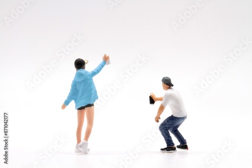 miniature figurines of a couple of writers painting an empty urban wall
