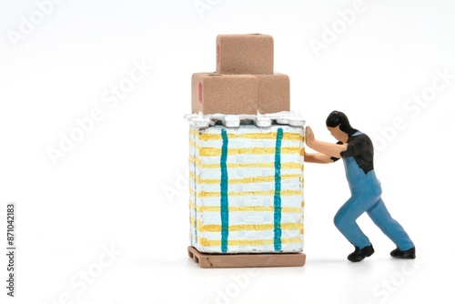 miniature figurine of a worker pushing an heavy pallet on a white background