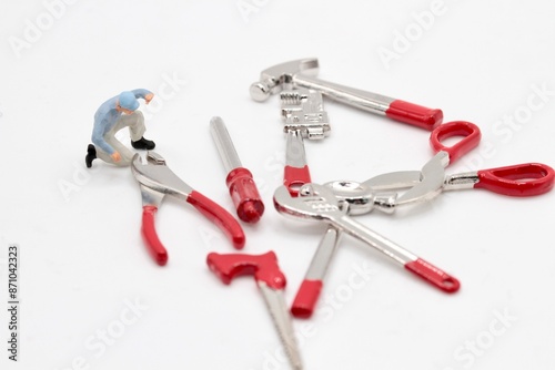 miniature figurine of a repairman with different toy tools