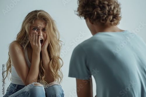 A distressed woman covering her face is comforted by another individual, emphasizing a moment of emotional support and human connection in a time of need. photo