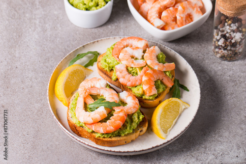 Shrimps on toast or sandwich with avocado and lemon. Breakfast concept. Bruschetta. 