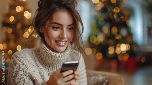 A woman wearing a cozy sweater, sitting and happily using a smartphone with Christmas lights in the background, capturing a warm, festive, and connected atmosphere.