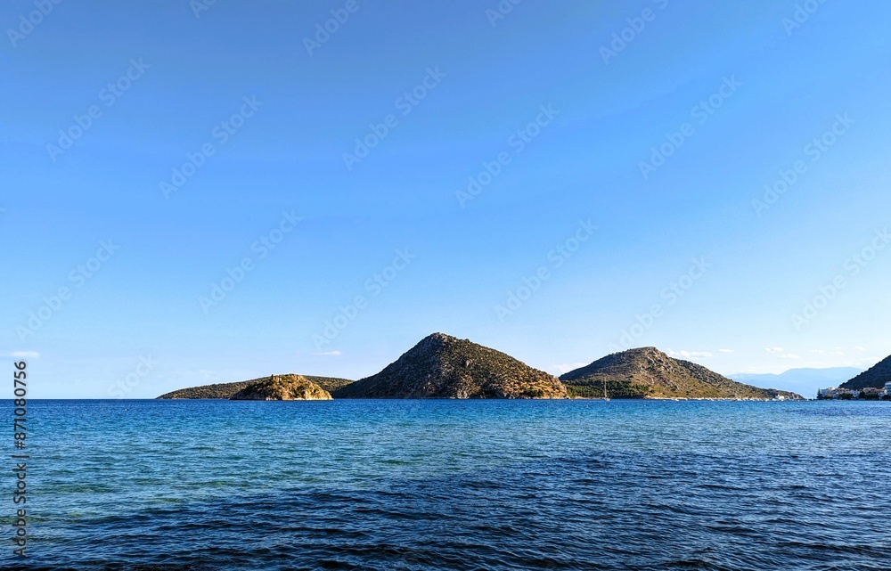 Beautiful view at the harbor of the small vacation resort Tolo in Greece on the sea with three hills in the horiziont Beautiful view at the harbor of the small vacation resort Tolo in Greece on the sea with three hills in the horiziont