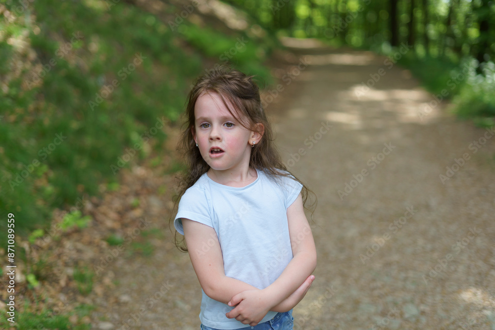 Surprised little cute preschooler girl on gravel path on blurred summer forest background. Happy childhood concept Surprised little cute preschooler girl on gravel path on blurred summer forest background. Happy childhood concept